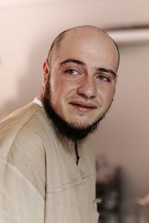 Close-up do acompanhante com olhar emocionado e focado no processo de parto.'