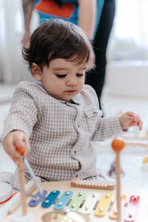 Aniversariante brincando co brinquedos de madeira.'