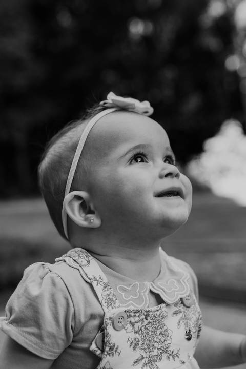 Foto da bebê olhando pra cima em preto e branco. '