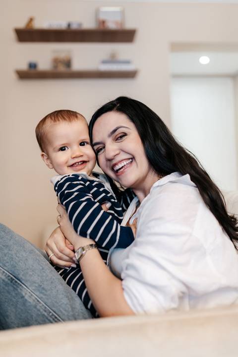 Eduardo no colo da mamãe Isabela durante o ensaio de 1 ano, em um momento espontâneo e cheio de carinho.'