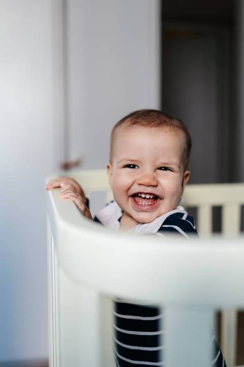 Bebê sorrindo durante o ensaio fotográfico em comemoração ao seu primeiro aniversário.'
