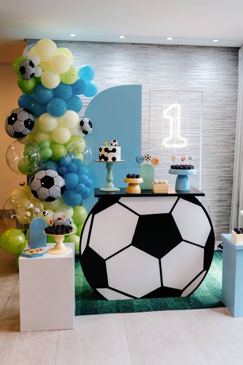 Mesa principal da festa de 1 ano, com bolo, doces e decoração inspirada em futebol.'