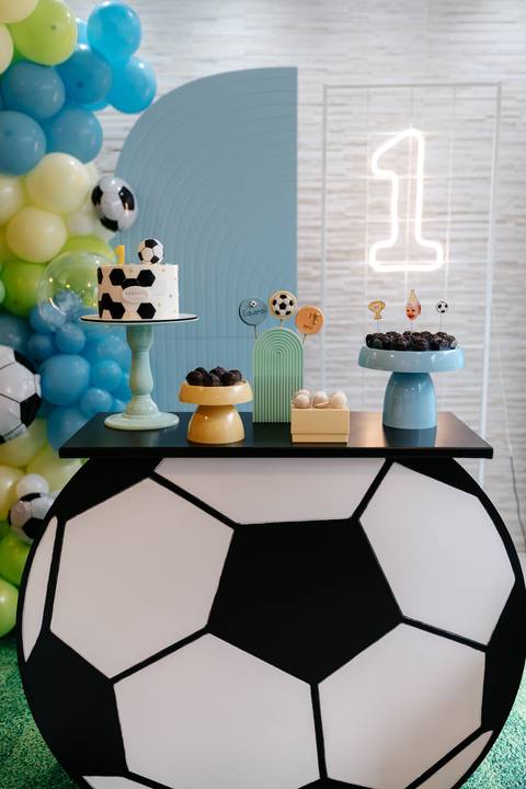 Mesa decorada para o primeiro aniversário, com bolo, doces e elementos da festa'