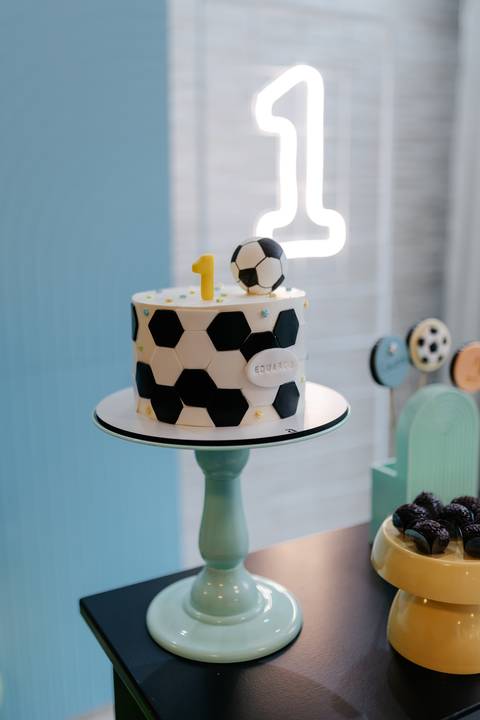 Detalhe do bolo de 1 ano com decoração inspirada em futebol.'