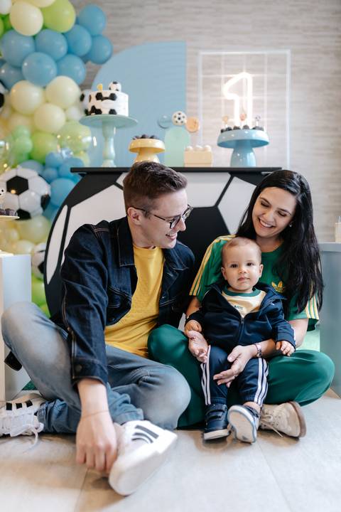 Pais juntos em um momento de carinho durante a comemoração em família.'