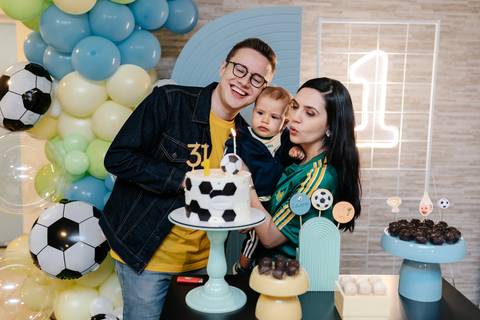 Foto da família reunida diante da decoração da festa de 1 ano'