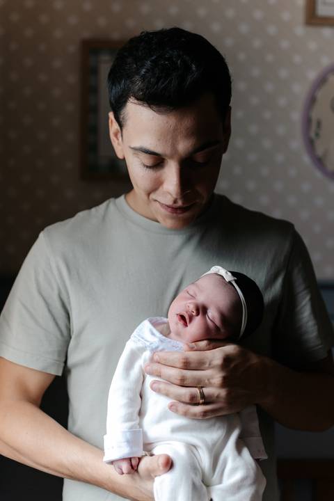 Pai e bebê compartilhando um momento de carinho nos primeiros dias de vida.'