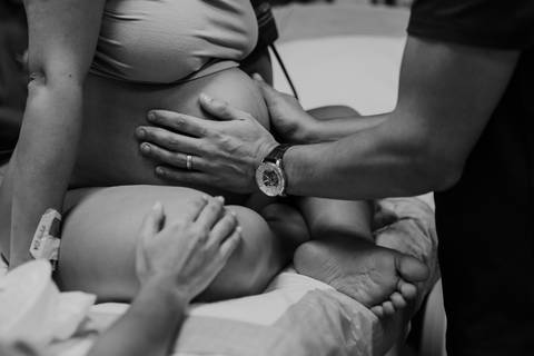 Registro delicado dos momentos que antecedem o nascimento durante o parto cesárea.'
