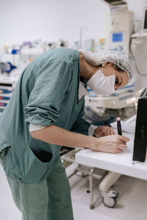 Médica preparando a touca personalizada do bebê'
