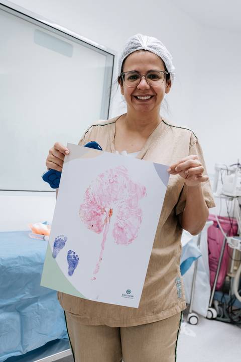 Enfermeira segurando a impressão da placenta em papel.'