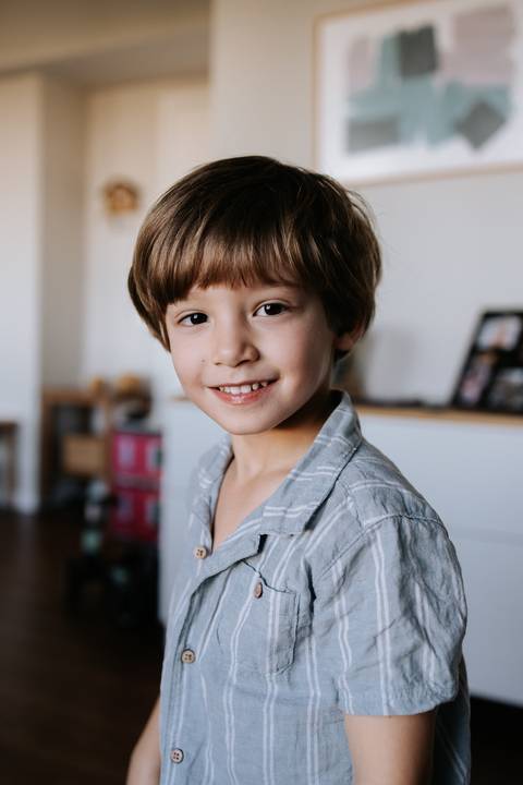 Retrato em close-up do menino sorrindo na sala.'