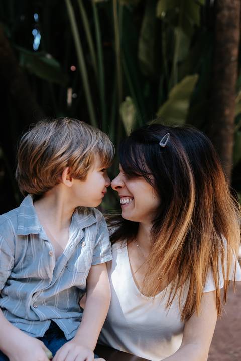 Mãe e filho encostando os narizes em momento carinhoso.'