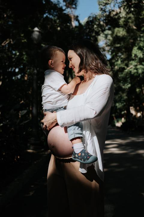 Mãe e filho trocando olhares carinhosos no parque.'