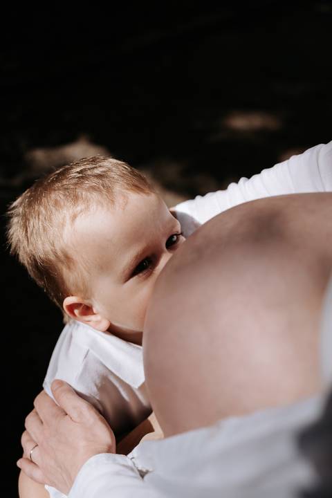 Close do menino encostando a bochecha na barriga da mãe.'