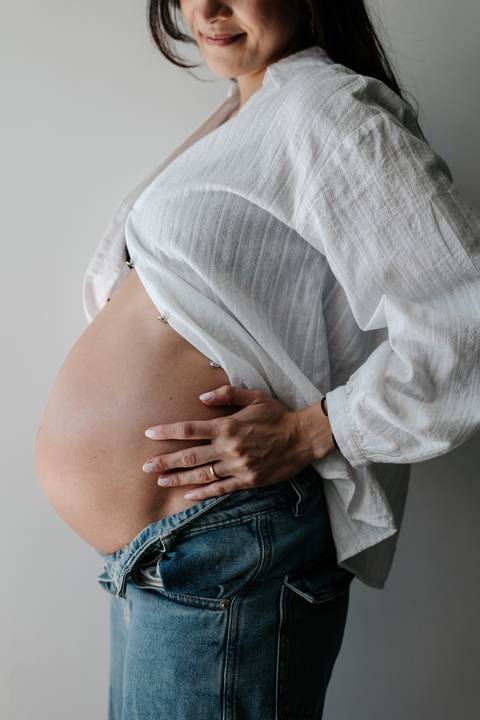 Close-up da mão da gestante na barriga.'