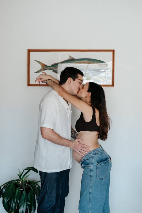 Casal se beijando com os braços ao redor do pescoço.'