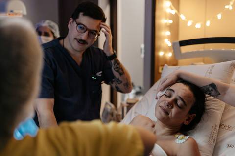Casal emocionado aguardando o momento imediato do nascimento.'