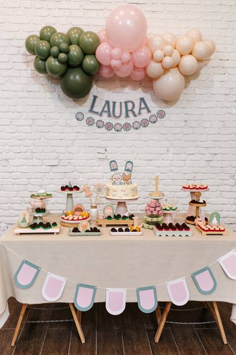 Visão geral da mesa do bolo decorada com painel do nome 