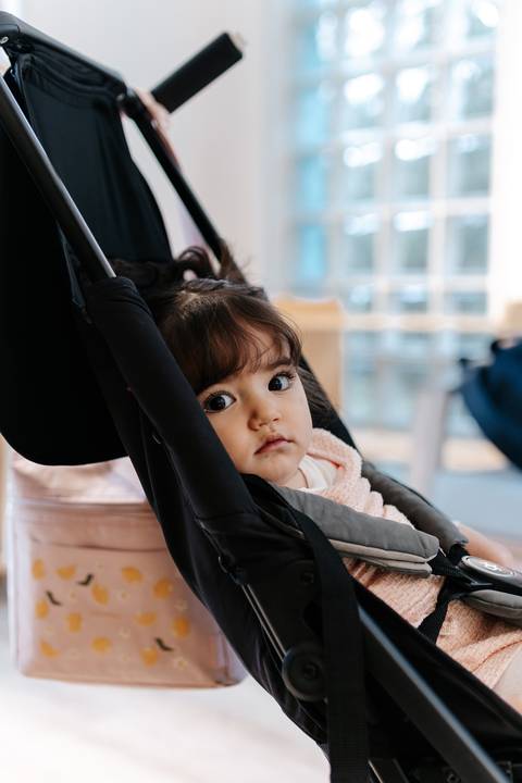 Close da aniversariante olhado curiosa do carrinho de bebê.'