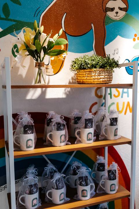 Prateleira com as lembrancinhas personalizadas da festa organizadas.'