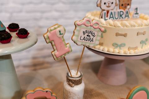 Biscoito decorado em formato do número 1 e bolo personalizado.'