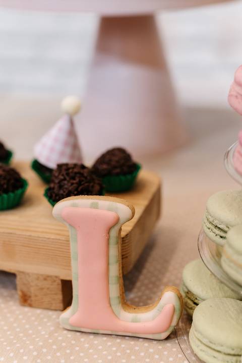 Docinho de colher e biscoito personalizado com a letra L.'