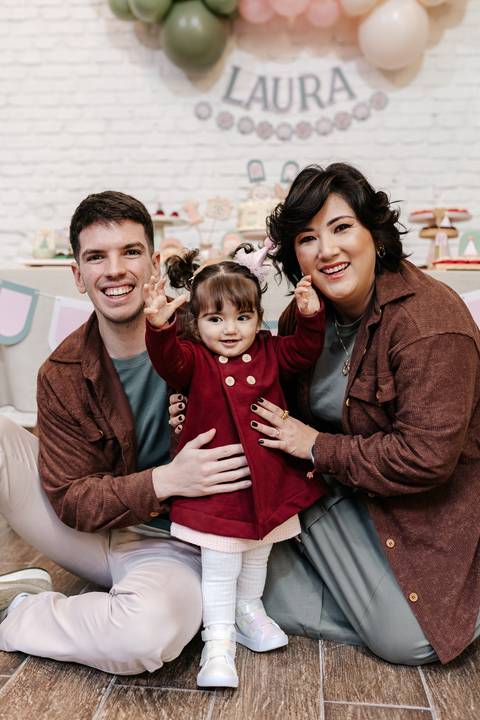 Família reunida acenando felizes para a foto principal da festa.'