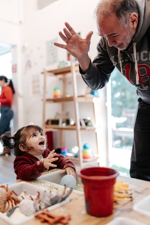 Aniversariante rindo e olhando para cima durante as brincadeiras.'