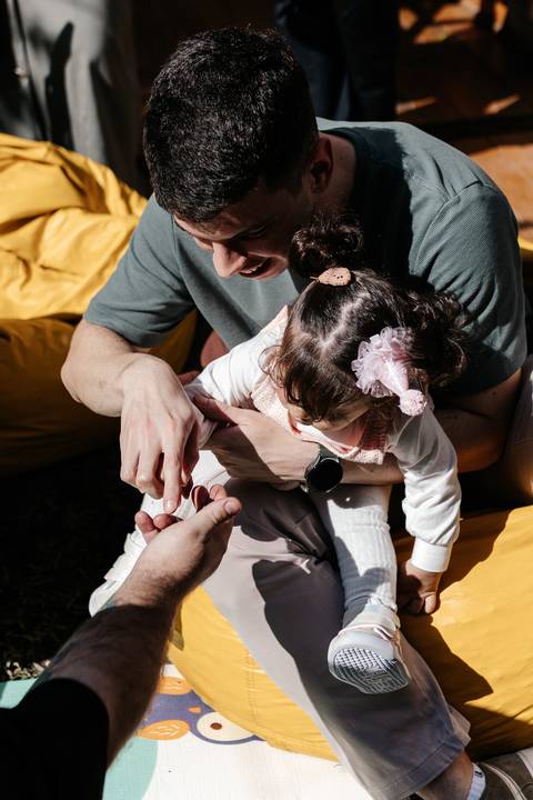 Pai e filha interagindo e descobrindo elementos na recreação.'