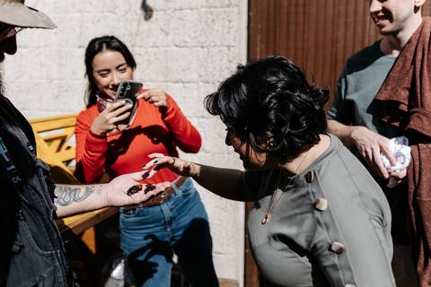 Convidados tocando na pele de uma cobra com mediação do biólogo.'