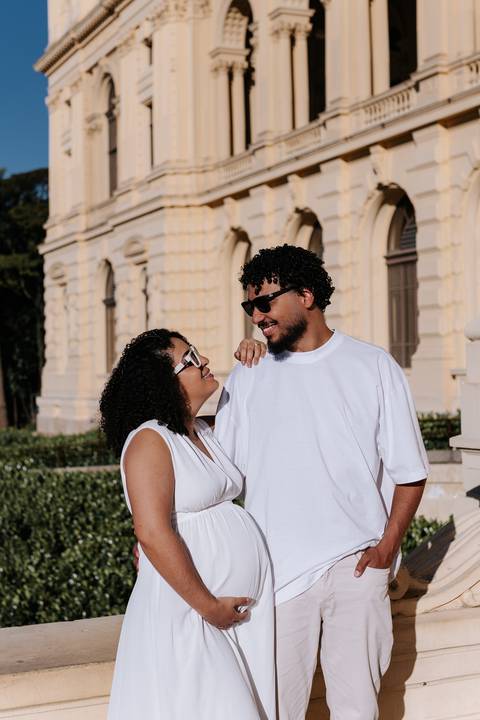 Casal de óculos de sol trocando olhares descontraídos na praça.'