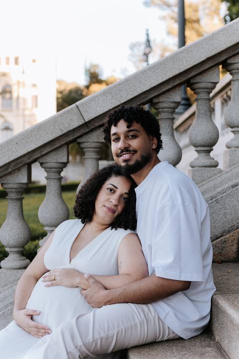 Casal posando junto aos degraus de pedra da escadaria histórica.'