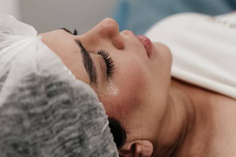 Close do rosto da mãe com lágrima de emoção escorrendo.'