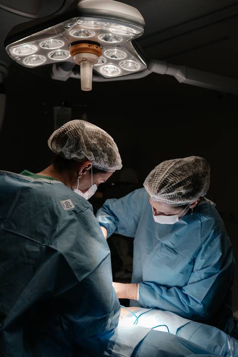 Médicas obstetras atuando concentradas no procedimento cirúrgico.'