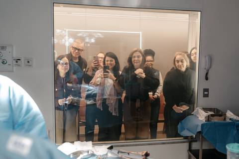 Família emocionado assistindo ao parto pelo painel de vidro.'