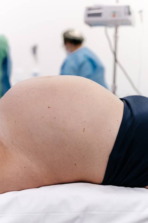 Close-up da barriga de gestante momentos antes do parto.'