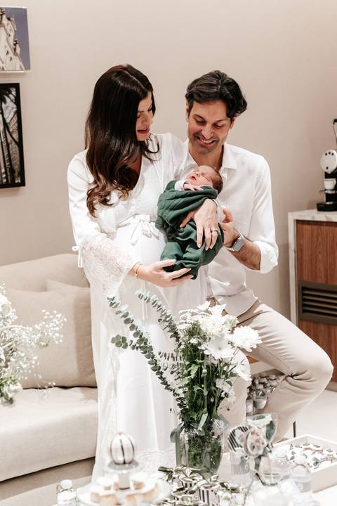 Casal posando elegante em pé perto das flores de recepção.'
