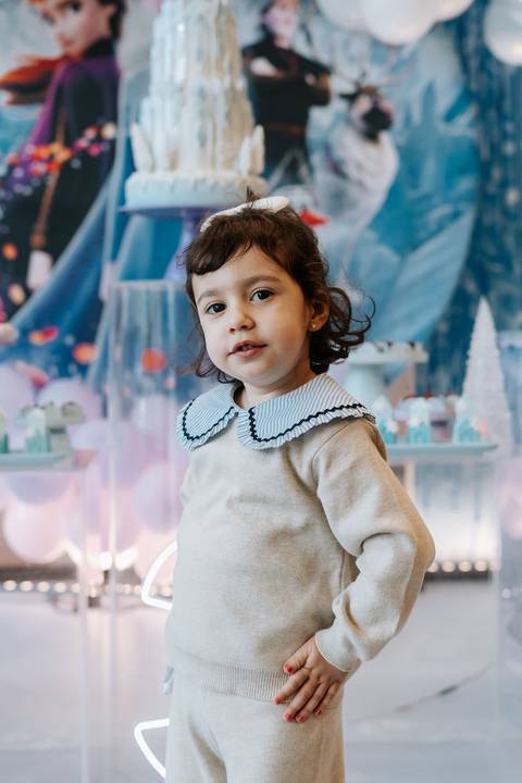 Zoe sorrindo em meio à decoração temática de Frozen'