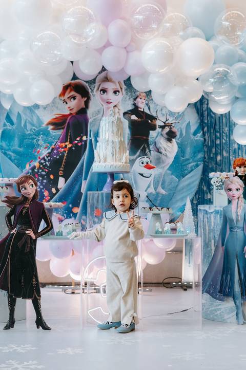 Zoe sorrindo em meio à decoração temática de Frozen'