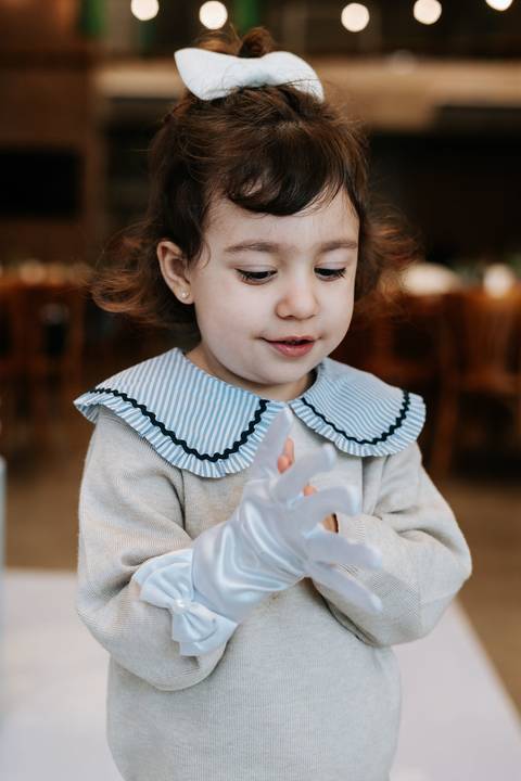 Zoe brincando durante festa infantil cercada pela família'