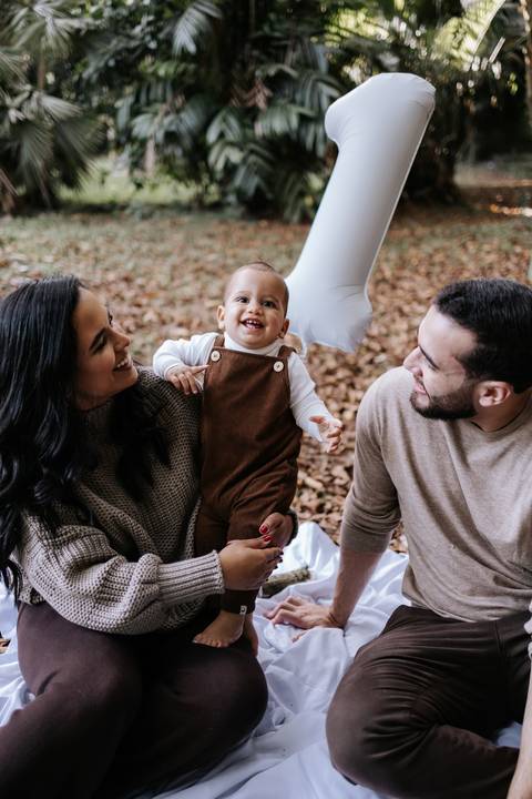 Rafael entre os pais durante ensaio de 1 ano em meio à natureza'