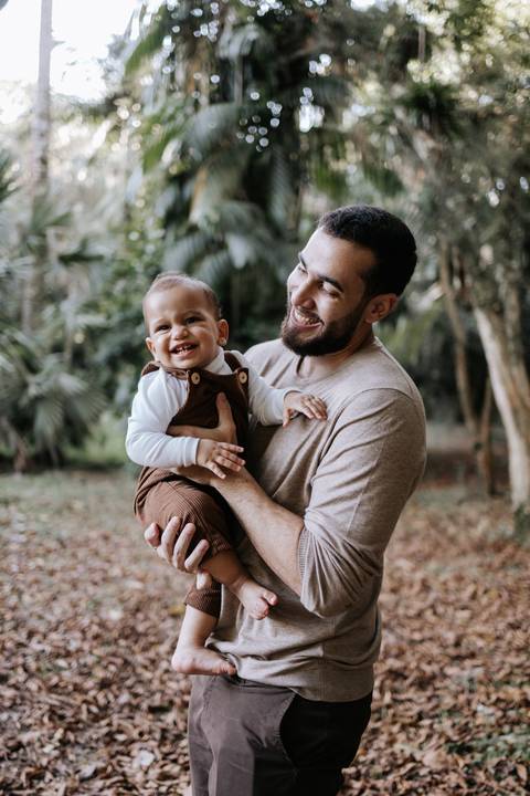 Matheus segurando Rafael no colo durante ensaio fotográfico de família'