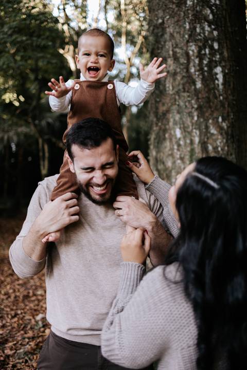 Rafael sentado nos ombros do pai durante ensaio fotográfico de 1 ano'
