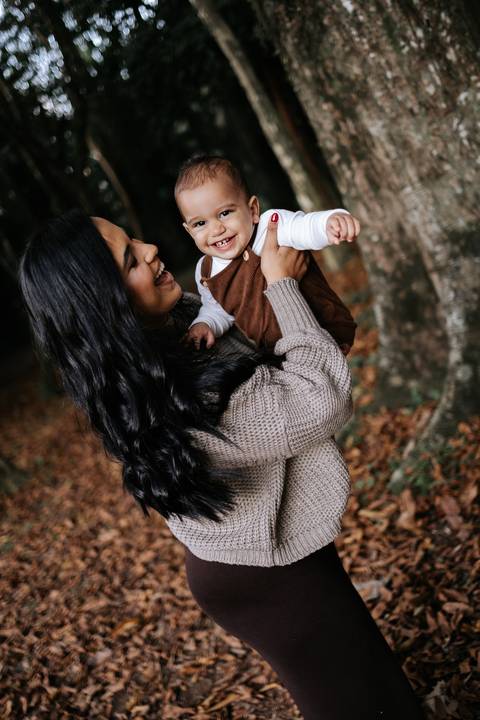 Rafael sorrindo no colo da mãe durante ensaio fotográfico de 1 ano'
