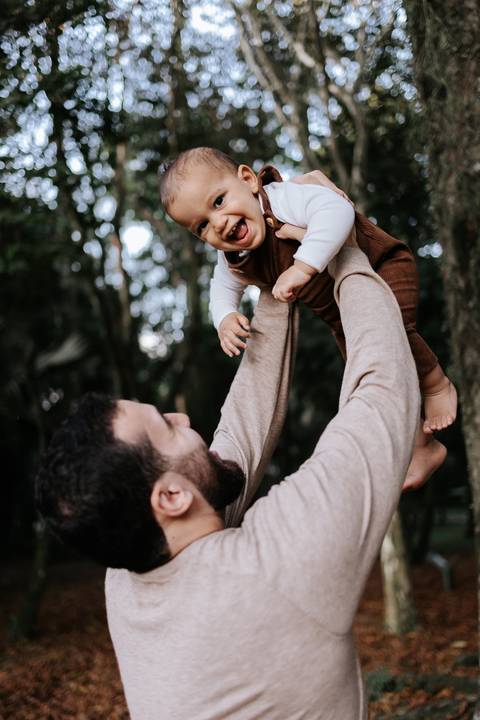Matheus levantando Rafael no ar durante brincadeira em família'