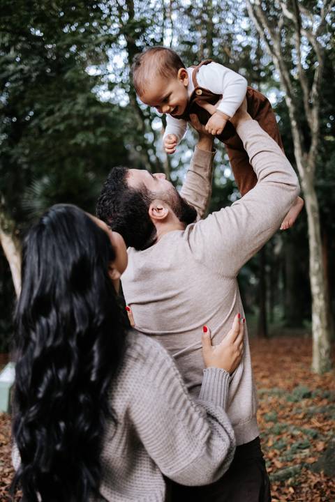 Pais levantando Rafael no colo durante brincadeira em família'