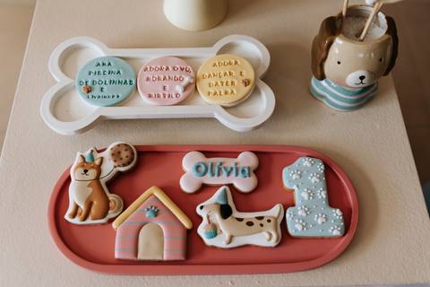 Detalhes da decoração da festa de 1 ano da Olívia, com docinhos, lembranças e elementos personalizados com o tema cachorrinho.'