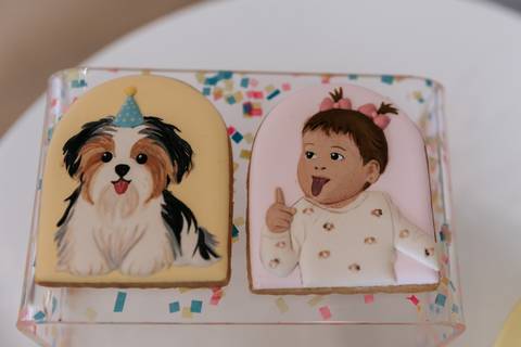 Doce personalizado com ilustração de um cachorro e uma criança, parte da decoração da festa de 1 ano da Olívia.'