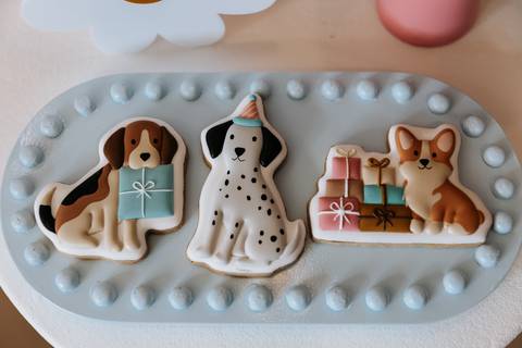 Docinhos decorados com diferentes cachorrinhos e presentes na mesa da festa de 1 ano da Olívia.'