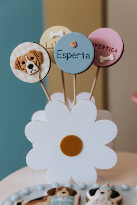 etalhe da decoração da festa de 1 ano da Olívia com elementos de cachorrinhos e balões coloridos.'